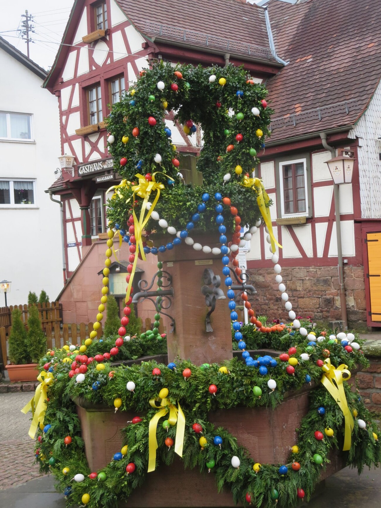 Kreuzbrunnen in der Dorfmitte Heiligkreuzsteinach von LandFrauen österlich geschmückt.