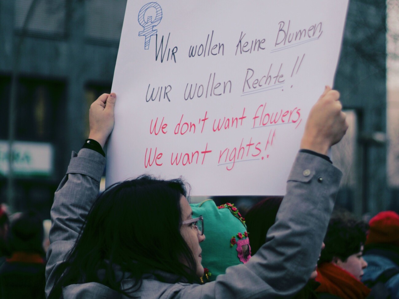 Demonstrantin setzt sich für die Rechte der Frauen ein mit einem Schild, auf dem steht 'Wir wollen Rechte.'