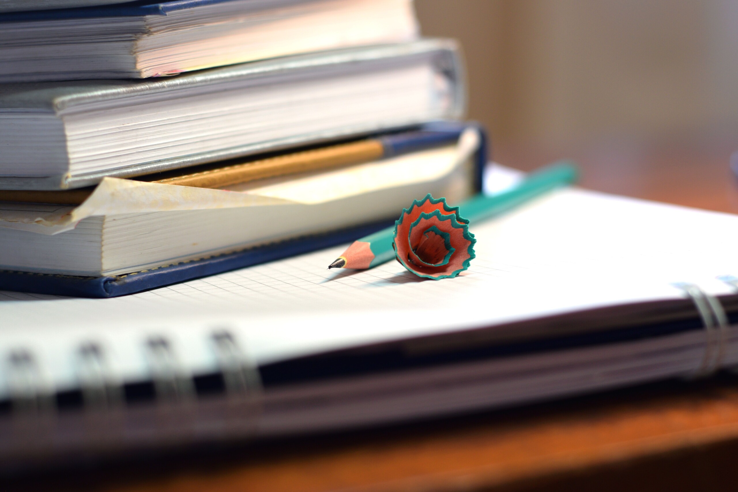Bücherstapel mit buntem Stift im Vordergrund